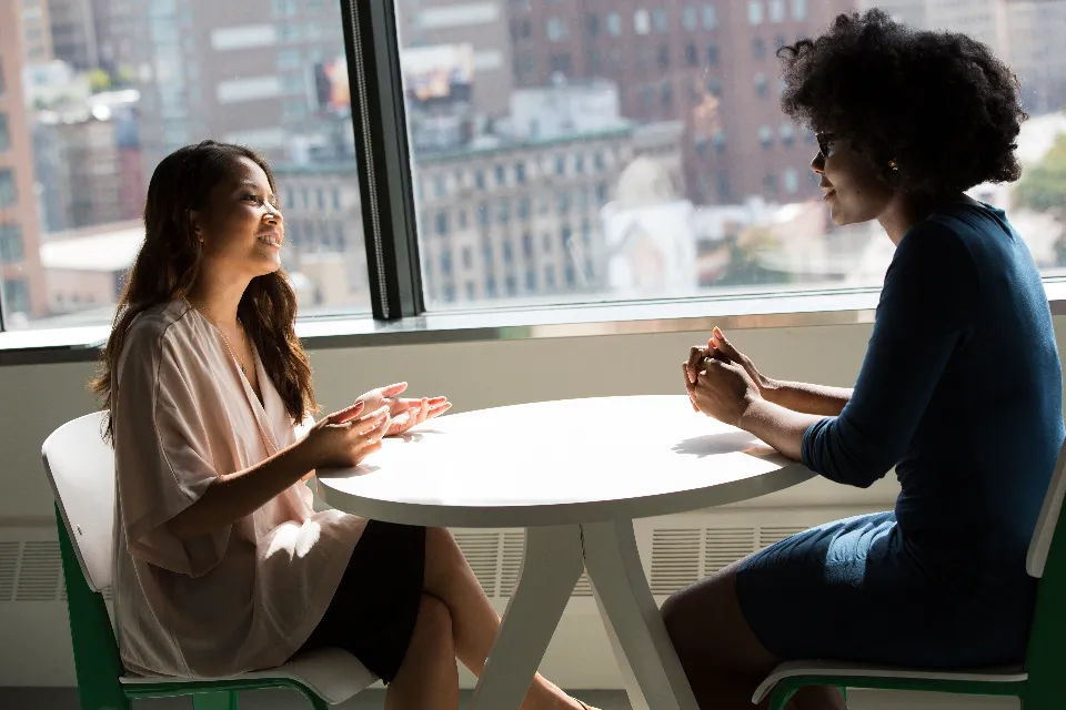Une conseillère échange avec une cliente autour d'une table