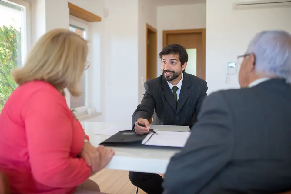 Un conseiller reçoit un couple de clients à son bureau