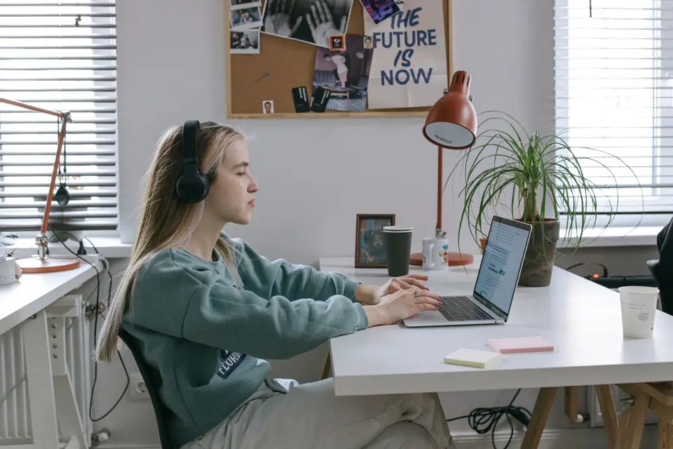 Une professionnelle suit une formation en ligne avec un casque, à son bureau