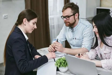 Une conseillère explique des documents financiers à un couple
