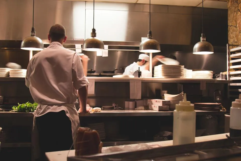 Cuisiniers au travail dans la cuisine d'un restaurant