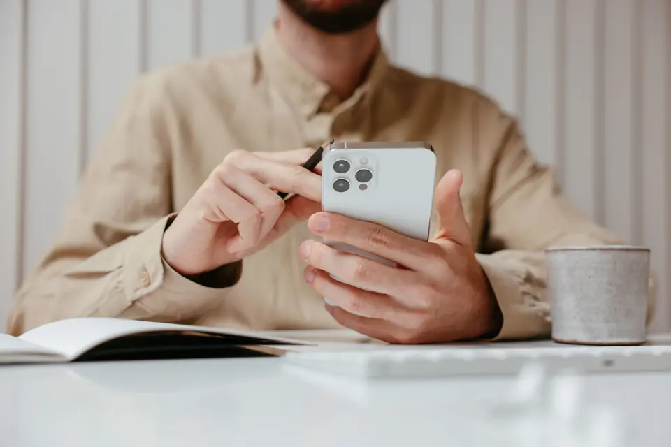 Un professionnel suit un module sur son smartphone, à son bureau