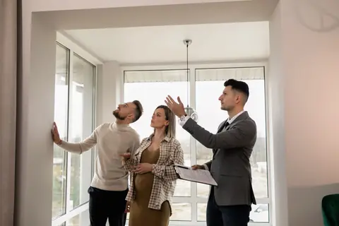 Un agent immobilier fait visiter un appartement lumineux à un couple