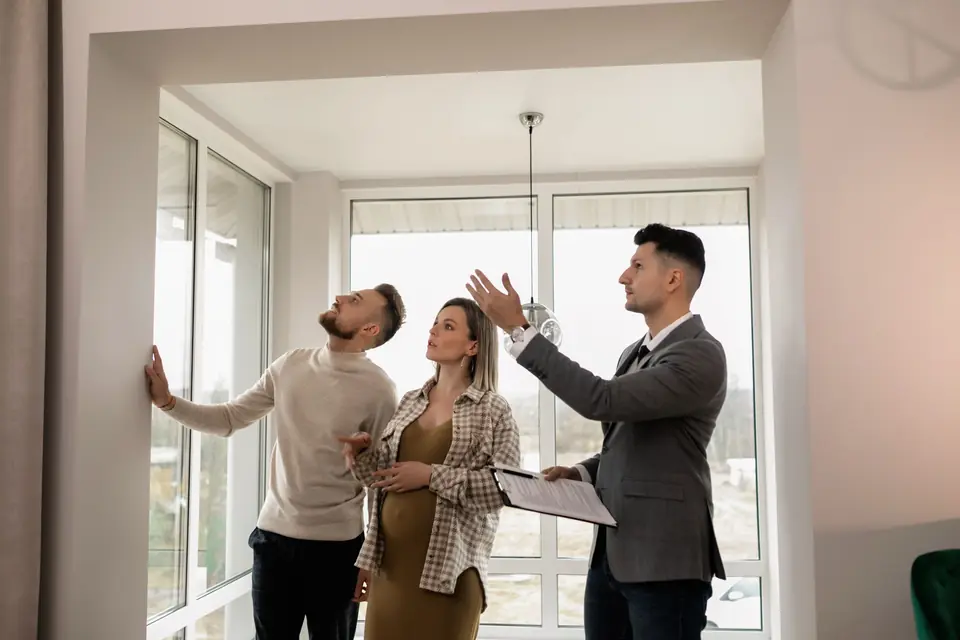 Un agent immobilier fait visiter un appartement lumineux à un couple